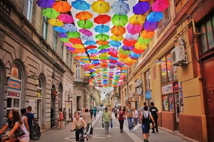 Romania corporation tax rate - A photograph of a Romanian street with a plethora of umbrellas at its apex.