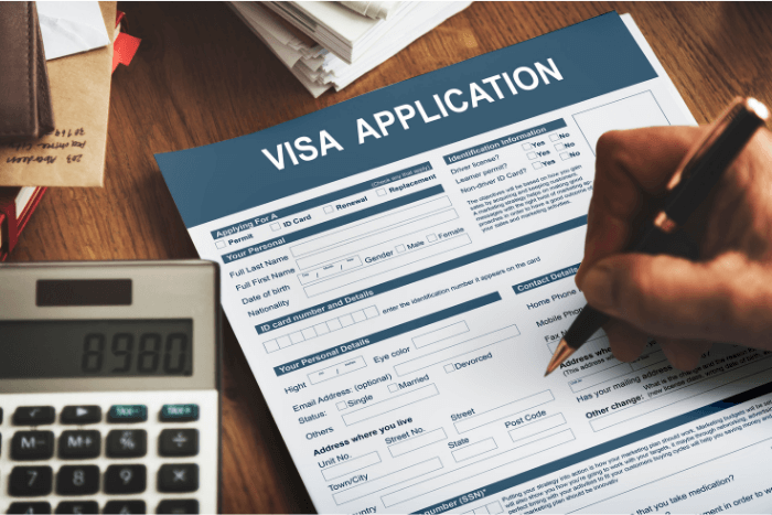 Hand filling out a visa application